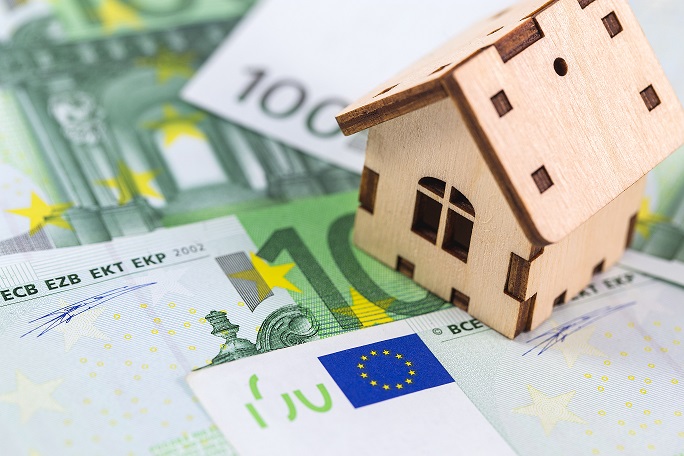 wooden symbol house and euro banknotes