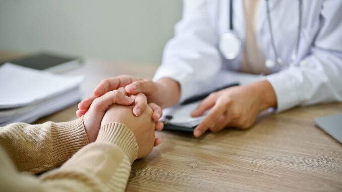 Close up view of doctor touching patient hand, showing empty and kindness.