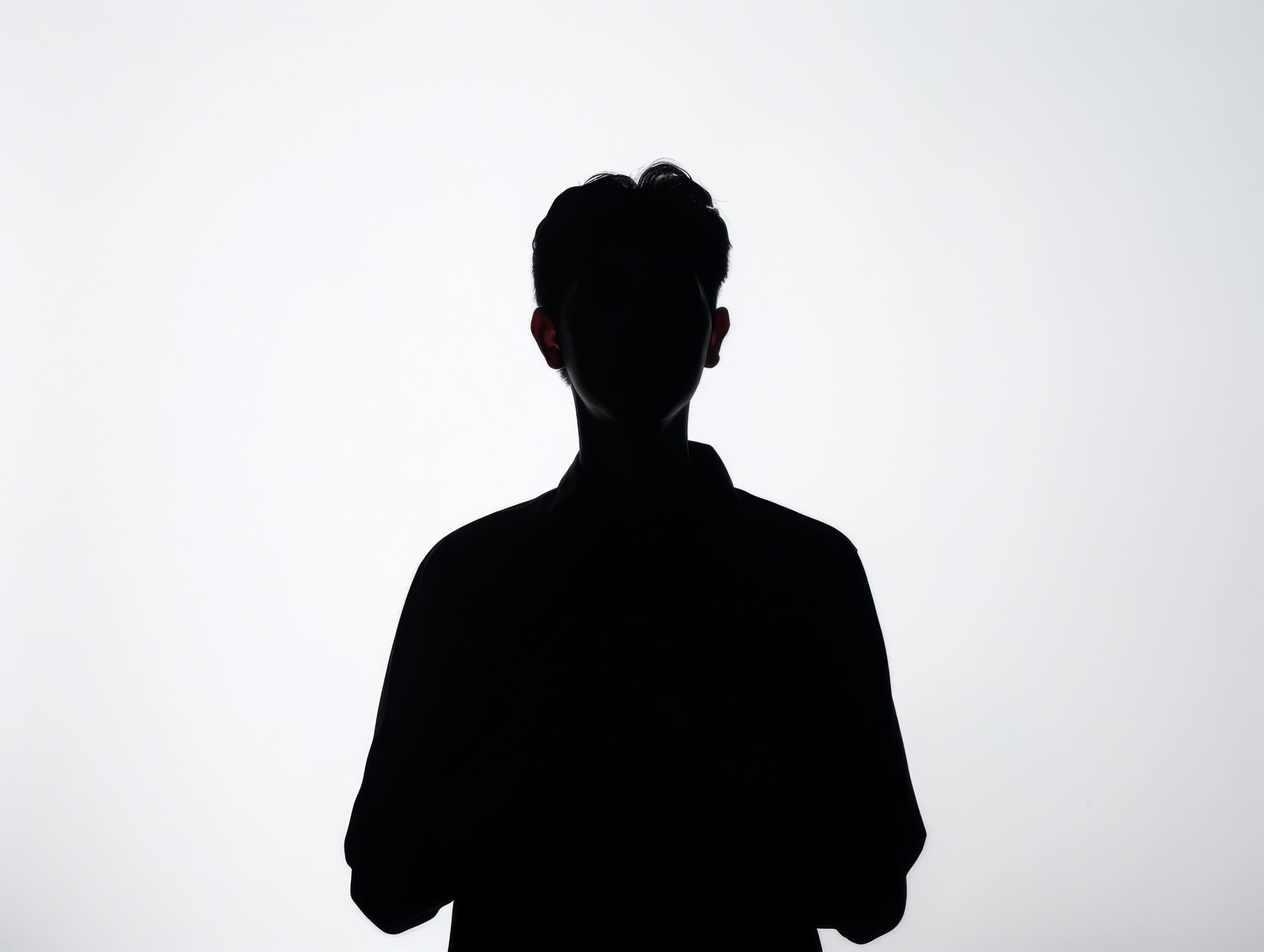 A man is standing in front of a white background