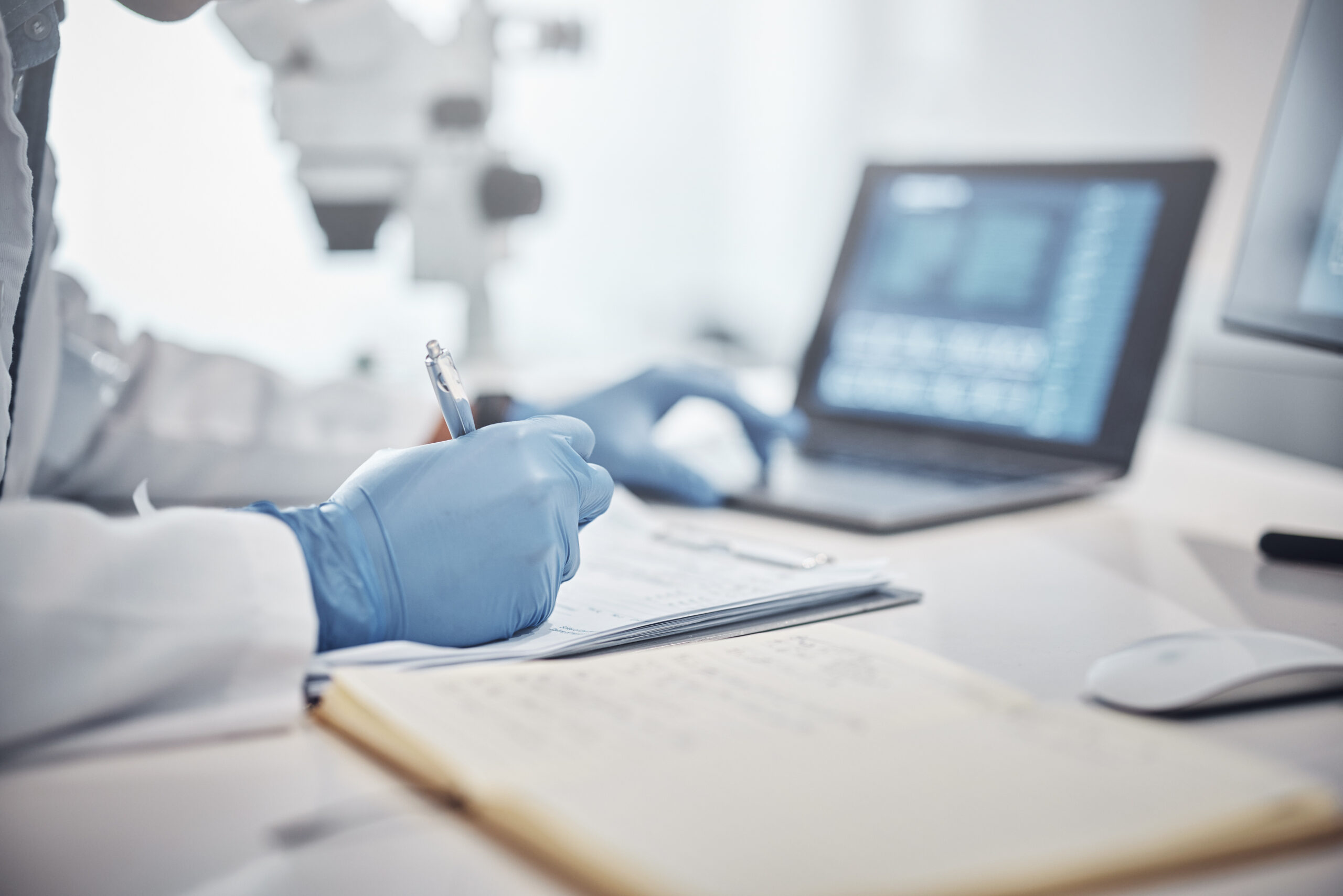 Science, research and hands in lab with notebook and computer on scientific analysis. Experiment, internet and analytics, scientist in laboratory with data, vision and future in medical innovation.